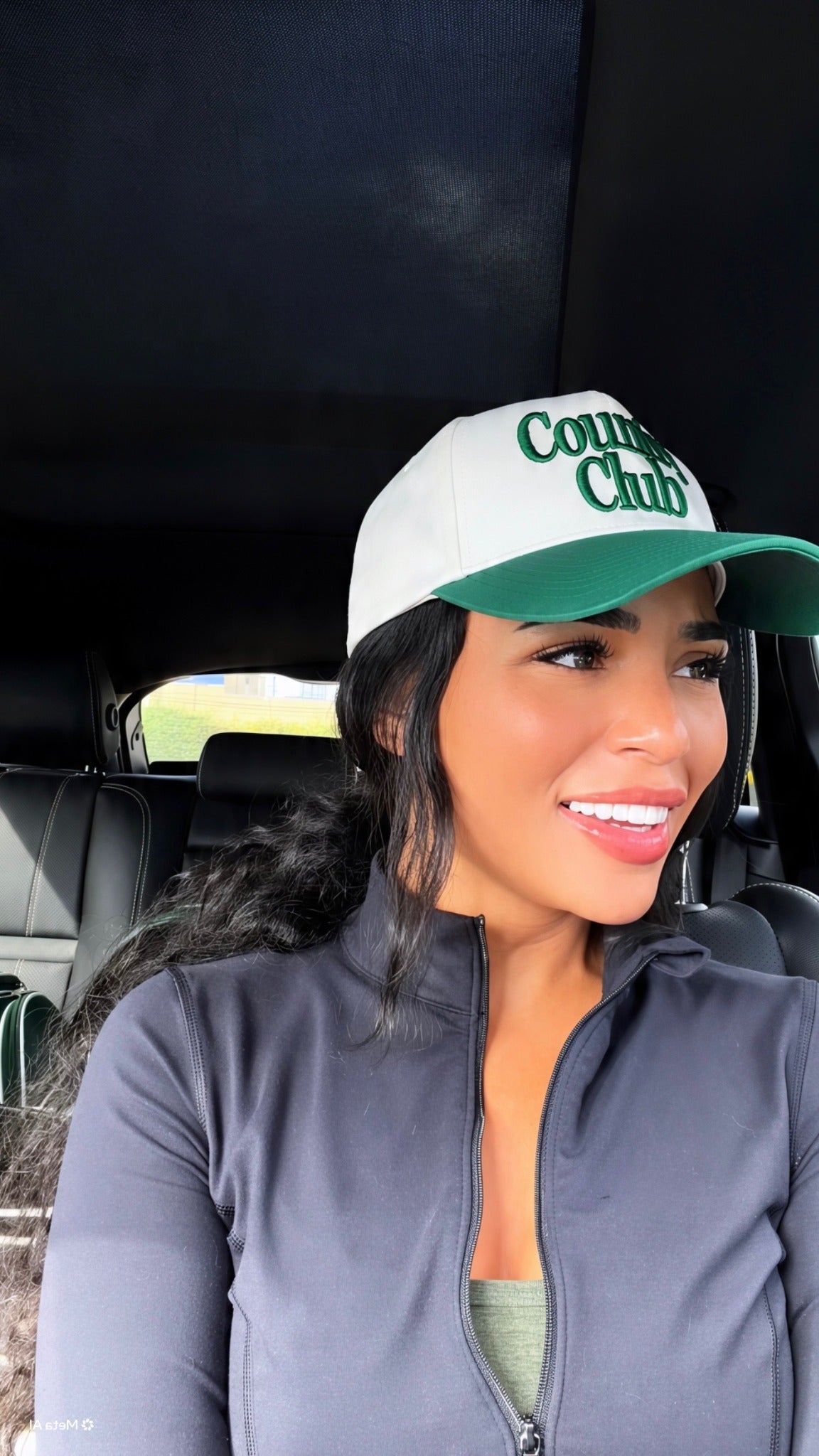 Country Club Destenee wearing green and white Country Club cap in car